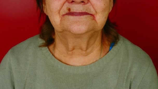Az idős nők egy része vörös háttérrel néz szembe. Felismerhetetlen mosolygós, érett nő testrésze. — Stock videók