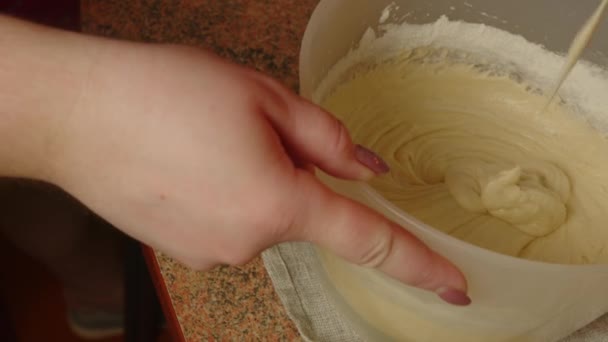 Felismerhetetlen személy habverővel keveri a tésztát a tálban. Ismeretlen háziasszony tésztát készít. Közelről. A házi sütéshez való tésztakészítés fogalma. — Stock videók