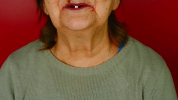Část starších žen se tváří na červeném pozadí. Nerozpoznatelná dospělá žena se usmívá s jedním zubem v ústech. Koncepce změn souvisejících se stárnutím. — Stock video