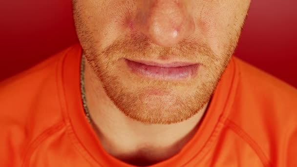 Crop man with diastema and toothy smile. Closeup high angle of unrecognizable redhead male with gaps between teeth on red background in studio — Stock Video