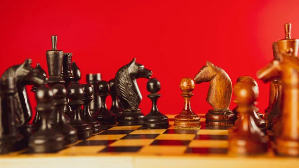 Dřevěné Šachové Figurky Šachovnici Rotující Červeném Pozadí Šachy Dřevěnými Figurkami — Stock fotografie