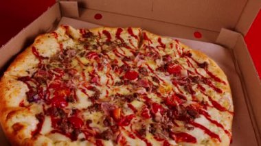 Kutuda büyük boy pizza. Farklı malzemelerle çevirilmiş lezzetli pizza. Kapatın. Fast food ve paket servis kavramı.