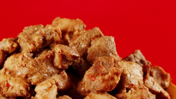 Succulents morceaux de viande dans une assiette jaune. Pile assaisonnée appétissante de viande filant sur fond rouge. Gros plan. — Video