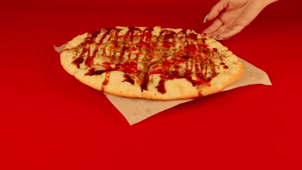 Appetitoso pizza piccola su sfondo rosso. La mano delle donne prende una fetta di pizza. Al rallentatore. Concetto di fast food e take away per merenda. — Video Stock