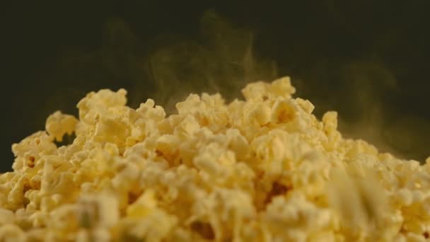 Tumpukan popcorn yang enak dengan uap yang menghilang. Orang tak dikenal melempar popcorn panas yang baru dimasak. Tutup. Konsep camilan untuk film. — Stok Video