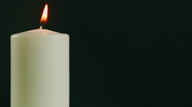 Siyah arka planda ya da karanlıkta yanan beyaz bir mum. Kederin Sembolü ve Dünya Kanser Günü