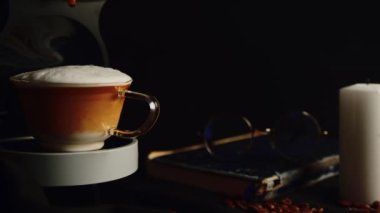 Kahve makinesinde bir kupa Cappuccino var ve fincanın içine kahve damlıyor. Kahve fincanı olan profesyonel bir kahve makinesi..