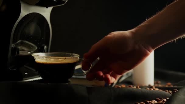 Siyah arka plandaki kahve makinesinden bir kupa Amerikano kahvesi alan bir adamın yakın çekimi. — Stok video