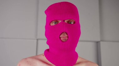 Pembe kar maskeli tanınmayan bir adamın portresi. Maskeli serseri kameraya bakıyor..