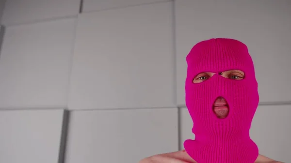Портрет неузнаваемого человека в розовой балаклаве. Хулиган в маске смотрит в камеру. — стоковое фото