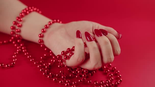 From above of crop anonymous woman with red beads and with red manicure on red background in studio — Stock Video