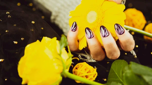 Erwachsene Frauen tragen stylische Strickhandschuhe mit lila Maniküre auf schwarzem Hintergrund. Schnappen Sie unkenntliche Person mit Design auf den Nägeln. Konzept von Pflege und Schönheit. — Stockfoto