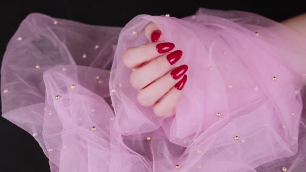 Frauenhand mit roten Nägeln. Weibliche Hand zeigt Maniküre auf rosa Hintergrund. — Stockvideo