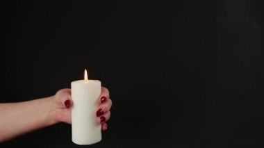 Yanan mumla çiftçi. Beyaz mum siyah arkaplan gösteren isimsiz bir kişi kes
