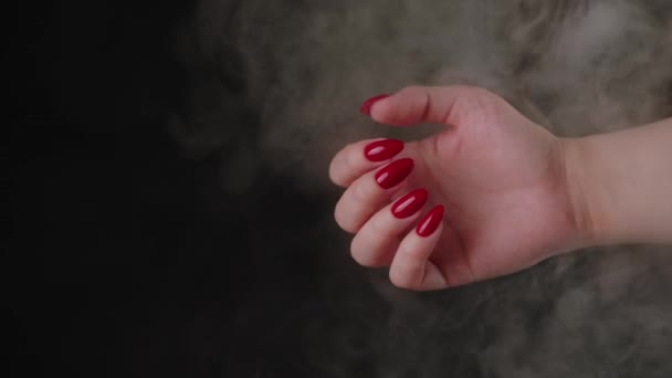 Crop woman with red nail polish. High angle of crop faceless female showing hands with red manicure against black background in studio — Stock Video