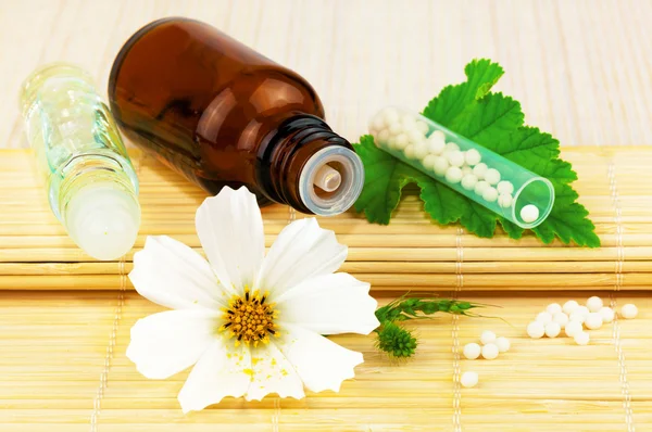 Homeopathic medication with flower and leaf — Stock Photo, Image