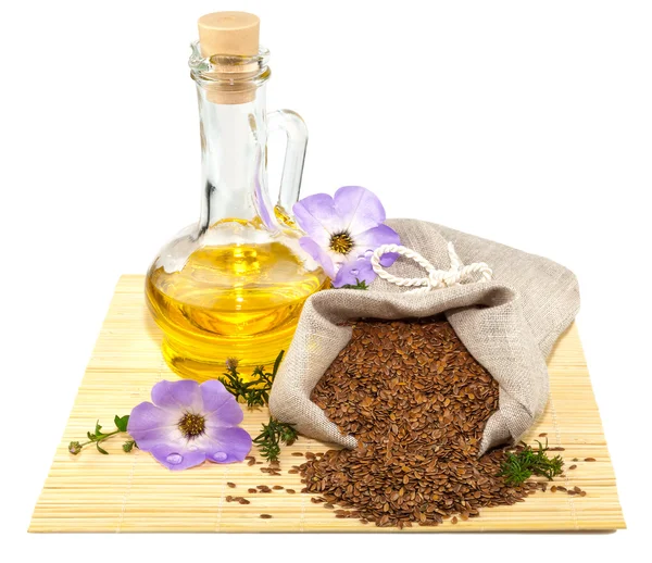 Sack of flax seeds and glass bottle of oil — Stock Photo, Image