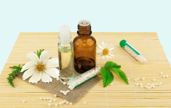 Homöopathische Medikamente mit Blüten und Blättern Stockbild
