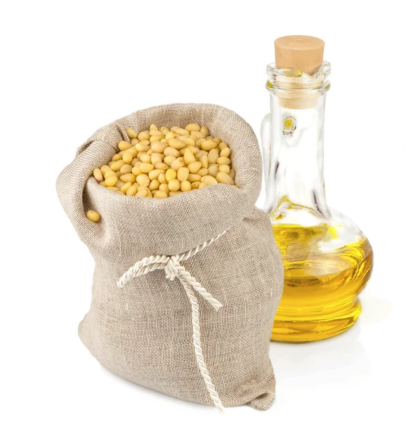 Sack of pine nuts and glass bottle of oil — Stock Photo, Image