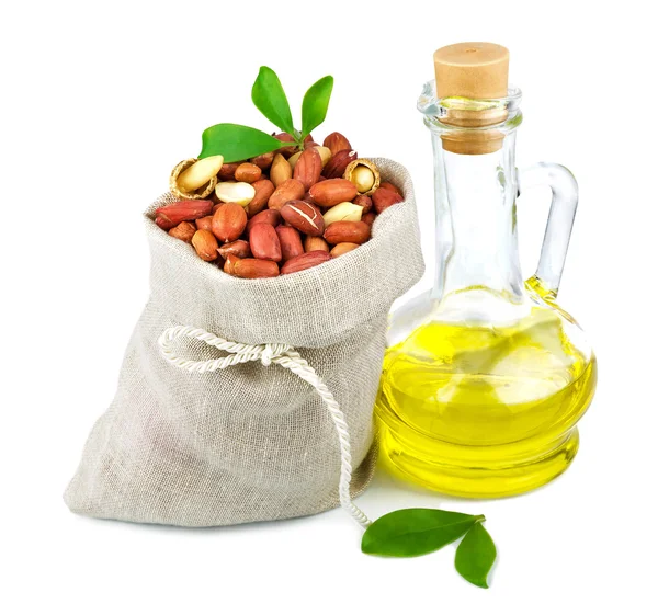 Sack of peanut and glass bottle of oil with leaves — Stock Photo, Image