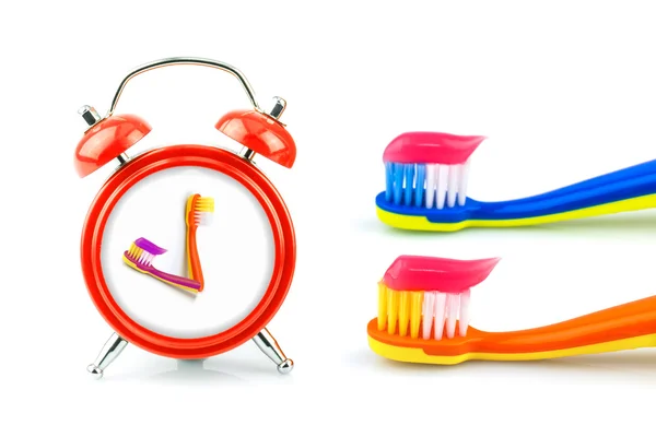 Composizione da orologio, spazzolini da denti con dentifricio — Foto Stock