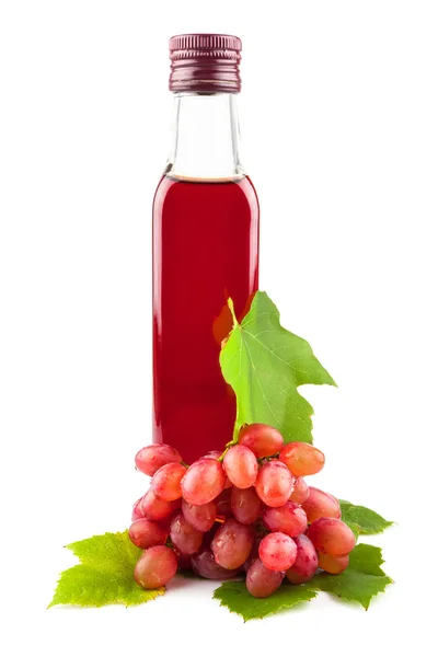 Glass bottle of red wine vinegar with grapes — Stock Photo, Image