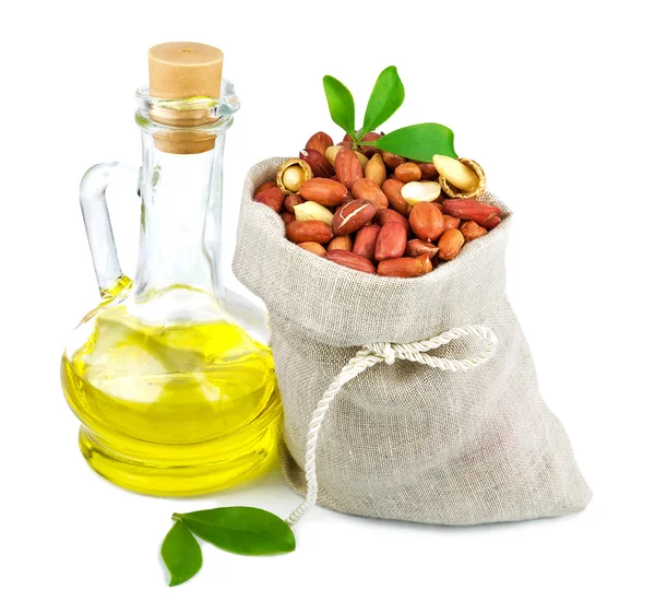 Sack of peanut and glass bottle of oil with leaves — Stock Photo, Image