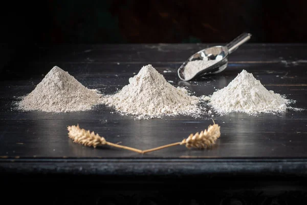 Three heaps of different wheat flour: whole wheat, sifted and white flour