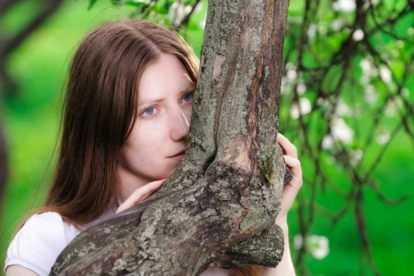 Thoughtful woman embraces tree — Stock Photo, Image