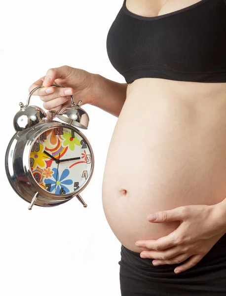 Kobieta w ciąży brzuch z budzikiem — Zdjęcie stockowe