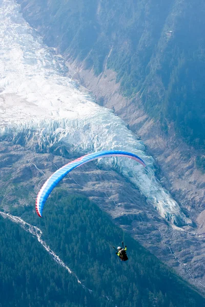 Parapente sobre o fluxo de gelo dos Alpes Fotografias De Stock Royalty-Free