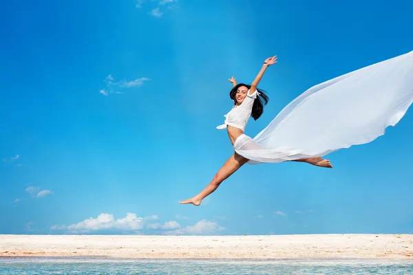 Mädchen springt gegen blauen Himmel — Stockfoto