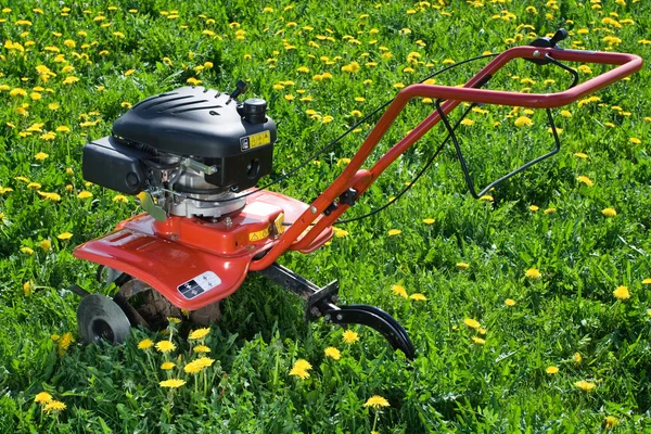 Aratro del trattore dal lato posteriore sul campo fiorito — Foto Stock