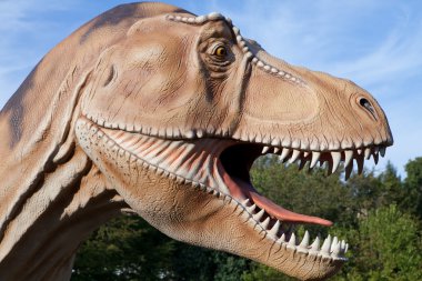 Reptile dinosaur tyrannosaurus rex on green tree and sky backgro