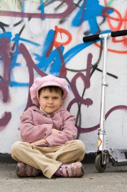 scooter grafiti boyalı duvar yakınlarında komik küçük kız