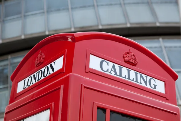 ファサードの背景にロンドンのシンボル赤い公衆電話ボックス — ストック写真