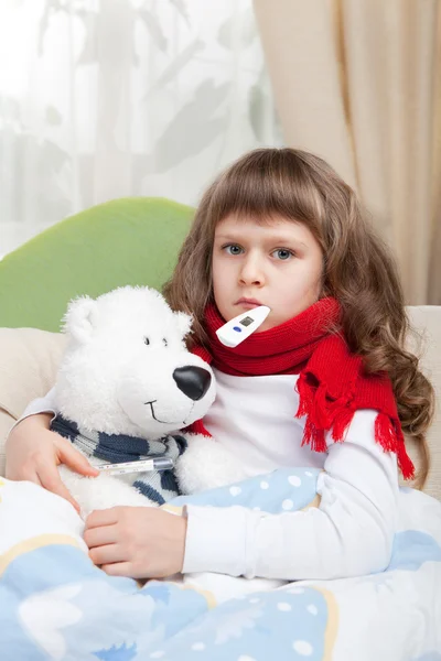 Petite fille malade avec thermomètre embrasse jouet ours au lit — Photo