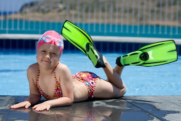 Little child in bathing cap, glasses, fins near swimming pool — Stock Photo, Image