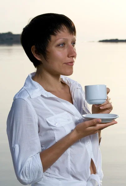 Young woman meets sunrise drinking morning coffee — Stock Photo, Image