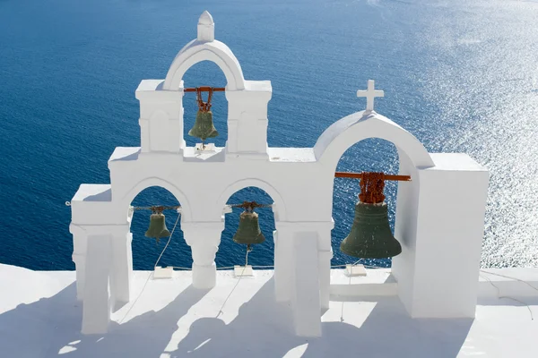 Mare calmo, arco bianco della chiesa, croce, campane Isola di Santorini Grecia — Foto Stock