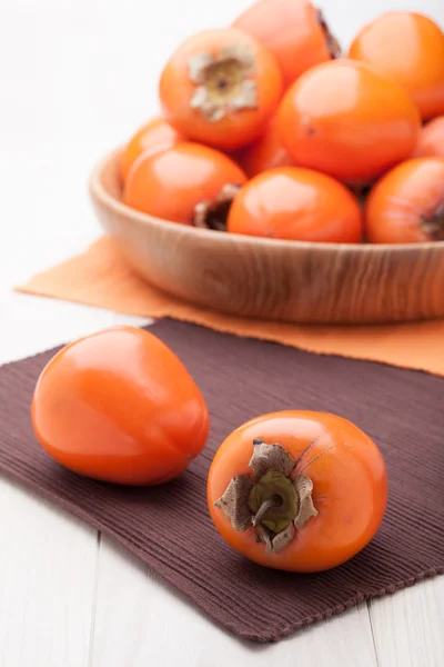 Exotic tropic orange fruits persimmon served in wooden plate — Stock Photo, Image