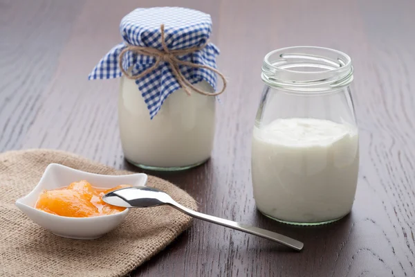 Hausgemachter Milchjoghurt mit Fruchtmarmelade in Porzellanschüssel auf dem Tisch lizenzfreie Stockfotos