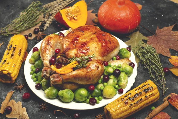 Pavo o pollo de Acción de Gracias para una cena festiva. Fondo de la mesa de alimentos con especialidades de temporada de otoño para el Día de Acción de Gracias. Pollo frito con calabaza, verduras y decoración otoñal sobre una madera — Foto de Stock