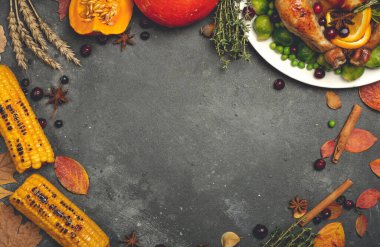 Şükran Günü yemeği için hindi ya da tavuk. Şükran Günü için sonbahar mevsimsel spesiyaliteleri olan yemek masası arka planı. Kızarmış tavuk, balkabağı, sebze ve sonbahar dekoru.