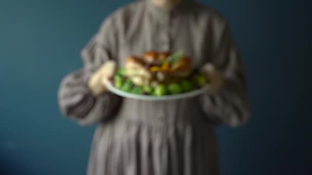 Hálaadási csirke egy háziasszony kezében. Sült csirke vagy pulyka zöldséggel díszítve egy tányéron hálaadási vacsorára. — Stock videók