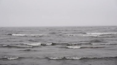  Bulutlu arka planda deniz. Kasvetli deniz manzarasında gri gökyüzü ve su.