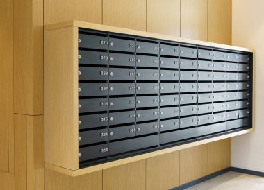 Mektuplar ve yazışmalar için posta kutuları. Konut veya ofis lobisinde numaraları olan modern siyah posta kutuları