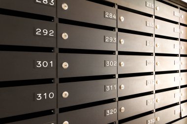 Mektuplar ve yazışmalar için posta kutuları. Konut veya ofis lobisinde numaraları olan modern siyah posta kutuları