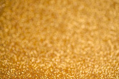 Pırıl pırıl altın arka plan. Doku folyosu ve konfeti bokeh, altın tozunun ışığı. Yılbaşı partisi ve yeni yıl arifesi geçmişi.