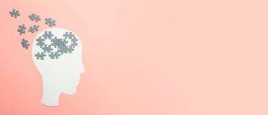 Bunama, Alzheimer, hafıza ve akıl sağlığı konsepti. Pembe arka planda yapboz parçaları olan kağıt kafa.